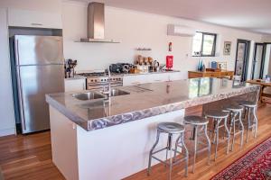 a kitchen with a large counter with bar stools at Tamar House in Rosevears