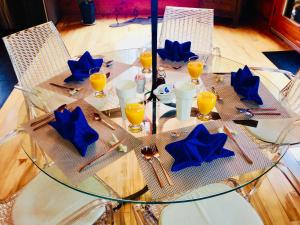 a glass table with chairs and blue napkins on it at Le Domaine du Lac Saint Charles in Quebec City