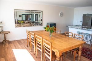 Tamar House في Rosevears: غرفة طعام مع طاولة خشبية عليها زهور
