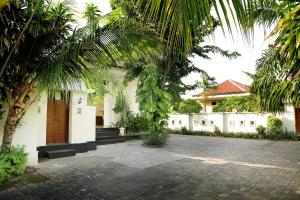 einen Innenhof eines Hauses mit Palmen in der Unterkunft Kaniya bali in Nusa Dua