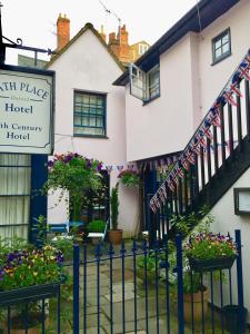 a building with a fence and flowers in front of it at Bath Place Hotel in Oxford