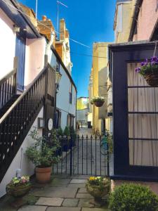 an alley with a gate and potted plants at Bath Place Hotel in Oxford