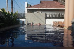 een persoon die zwemt in een zwembad bij Mom's Guesthouse in Siem Reap