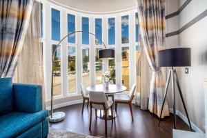 sala de estar con mesa, sillas y ventana grande en Century Park Hotel LA, en Los Ángeles