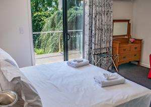 a bedroom with a bed with two towels on it at Tamar House in Rosevears