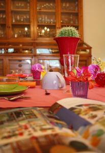 a table with a red table cloth with flowers on it at B&B La Locandiera in Castiglione della Pescaia