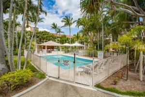 uma piscina com palmeiras e um resort em Miami Beachside Holiday Apartments em Gold Coast