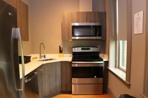 a small kitchen with a stove and a microwave at A Stylish Stay w/ a Queen Bed, Heated Floors.. #36 in Brookline