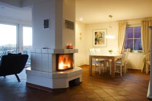 a living room with a fireplace and a dining room table at Ferienhaus *Traumblick* in Wittdün