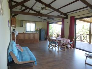 ein Wohnzimmer mit einem Tisch und einer Küche in der Unterkunft Chez Solange et Michel in Sainte-Rose