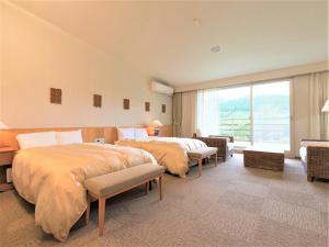 a hotel room with two beds and a large window at Mineyama Kogen Hotel Relaxia in Kamikawa