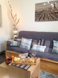 a living room with a blue couch with a tray of food at LossieBeach Apartment in Lossiemouth