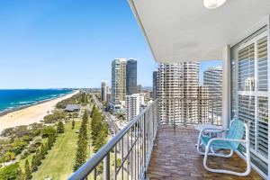 a balcony with a blue chair and the beach at Talisman Apartments in Gold Coast