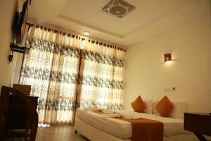 1 dormitorio con 1 cama y una ventana con cortinas en Sanu Lagoon Resort & Spa, en Tangalle