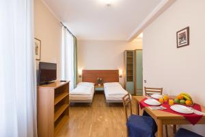 プラハにあるDuskova Apartmentsのリビングルーム(テーブル付)、ベッドルーム(ベッド1台、テレビ付)