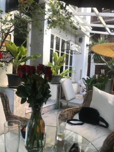 a glass vase with flowers on a glass table at Oriental Smile Hotel in Bangkok