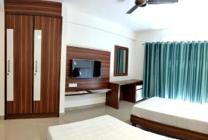 a hotel room with two beds and a television at Pride Home in Chandīgarh