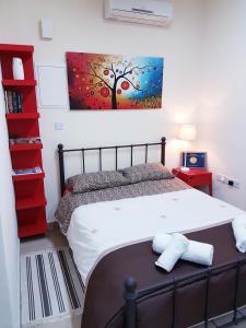 um quarto com uma cama e um quadro na parede em Kerynia Apartments em Pafos