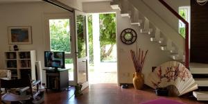 Sala de estar con escalera y reloj en la pared en N207 - Numana, deliziosa villetta con giardino, en Numana