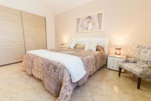 um quarto com uma cama grande e uma cadeira em A casa di Simona em Monreale