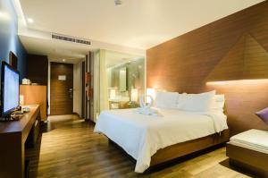 a hotel room with a bed and a flat screen tv at Beyond Resort Krabi in Klong Muang Beach