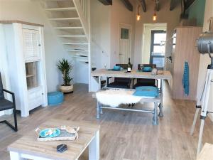a living room with a table and stairs at L'Ancora in Sint Annaland