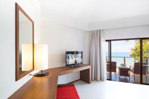 a living room with a television and a large window at Beyond Krabi in Klong Muang Beach