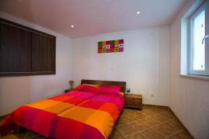1 dormitorio con 1 cama con una manta colorida en Anita Apartments, en Dubrovnik