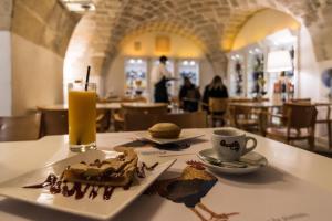 talerz jedzenia na stole ze szklanką soku pomarańczowego w obiekcie Elle Suite w mieście Lecce