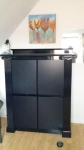 un comò nero in una stanza con un dipinto sul muro di didi logement a Westerlo