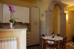 Toskana Relax في فيوتشيتشيو: مطبخ مع طاولة مع زجاجة من النبيذ