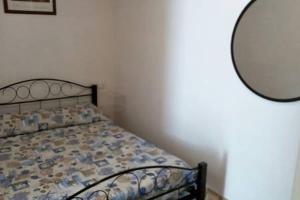 ein Bett in einem Schlafzimmer mit einem Spiegel an der Wand in der Unterkunft Casa Elsa in Biassa