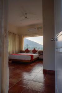 a bedroom with a bed with a large window at Willow Heights in Athirappilly