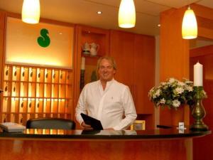 a man standing at a bar in a salon at Hotel Sterkel in Rödermark