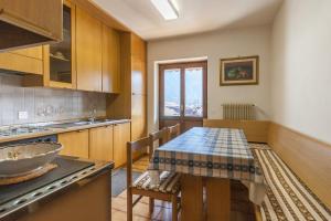 una cucina con tavolo, lavandino e piano cottura di Casa Elena a Canale dʼAgordo