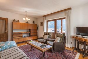 a living room with two couches and a tv at Casa Elena in Canale dʼAgordo