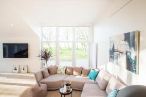 a living room with a couch and a large window at 5 Sterne Ferienhaus Emmelsbüll in Emmelsbüll-Horsbüll