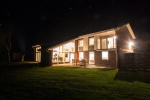 ein Haus in der Nacht mit eingeschaltetem Licht in der Unterkunft 5 Sterne Ferienhaus Emmelsbüll in Emmelsbüll-Horsbüll