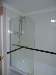 a shower stall with a glass door in a bathroom at Myrtle Cottage in Johnshaven
