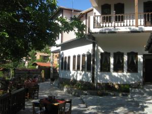 a white building with tables and chairs in front of it at комплекс ВОДОПАДА in Plovdiv