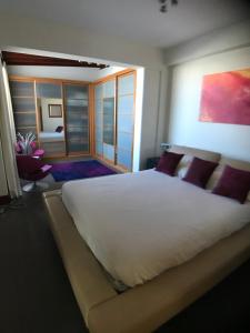 ラスパルマス・デ・グランカナリアにあるLas Palmas Penthouseのベッドルーム(紫色の枕が付いた大きな白いベッド付)