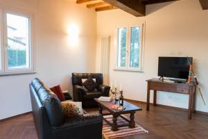 un salon avec deux fauteuils et une télévision dans l'établissement Casa Laura Capannori, à Capannori