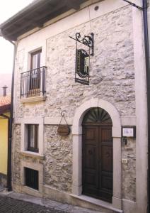 een oud stenen gebouw met een deur en een balkon bij Anticarua B&B in Opi