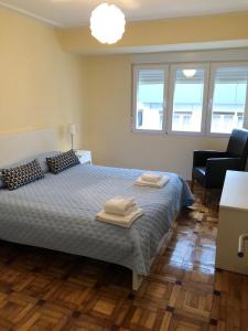 1 dormitorio con 1 cama con 2 toallas en Madala XXI en Oviedo