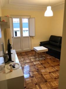 - un salon avec un canapé noir et une table dans l'établissement Madala XXI, à Oviedo