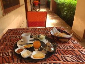 a table with a tray of breakfast food on a rug at Villa Rose in Bobo-Dioulasso