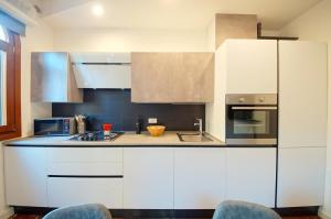 a kitchen with white cabinets and a microwave at DolceVita Apartments N 439 in Venice