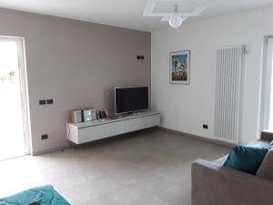 a living room with a television and a couch at Casa Punta Veleno in Brenzone sul Garda