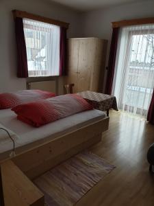 a bedroom with a bed and two windows at Residence Alpenblick in Valles