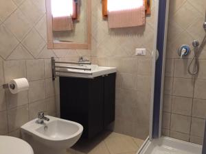 e bagno con lavandino, servizi igienici e doccia. di Kimera Beach Apartments a Vieste